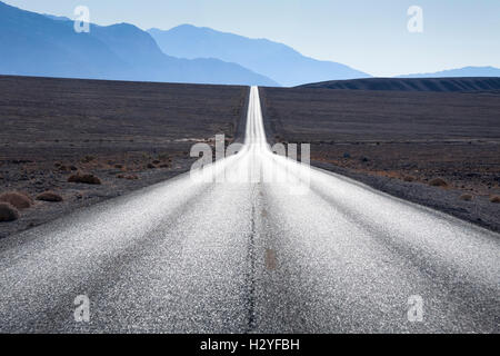 Strada diritta verso la gamma della montagna in orizzonte a Death Valley, Stati Uniti d'America