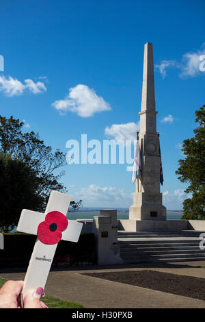 Femmina su mano per mettere una croce in un memoriale di guerra. Foto Stock