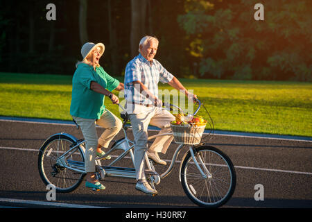 Coppia senior in bici in tandem. Foto Stock