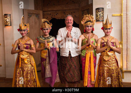 Indonesia, Bali, Amed, gruppo di giovani femmine ballerini Balinesi con vecchi western tourist indossando sarong Foto Stock