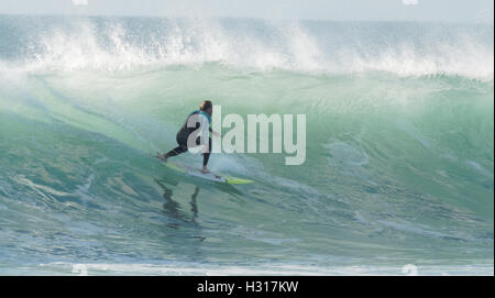 Lone surfer rides enorme back lit sunshine surf REGNO UNITO Foto Stock