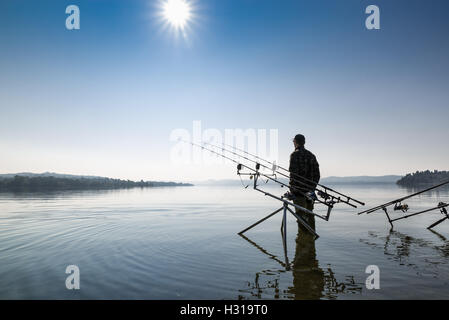 Le avventure di pesca. Fisherman vicino al carpfishing attrezzatura Foto Stock