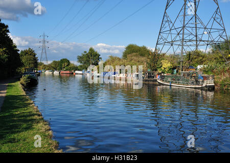Il fiume Lea, vicino a Tottenham, North London UK, con barche a remi e piloni, in estate Foto Stock