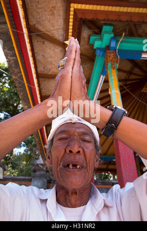 Indonesia, Bali, Sawan, Jagaraga, Pura Dalem tempio, il sacerdote Indù in preghiera con le mani insieme Foto Stock