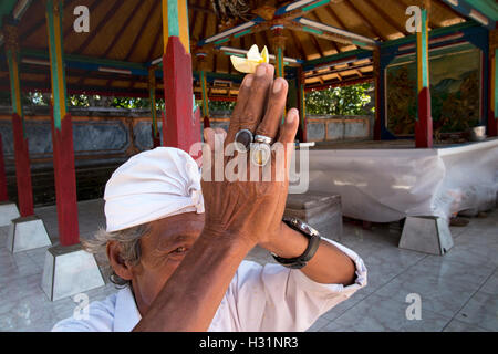 Indonesia, Bali, Sawan, Jagaraga, Pura Dalem tempio, mani del sacerdote Indù in preghiera Foto Stock