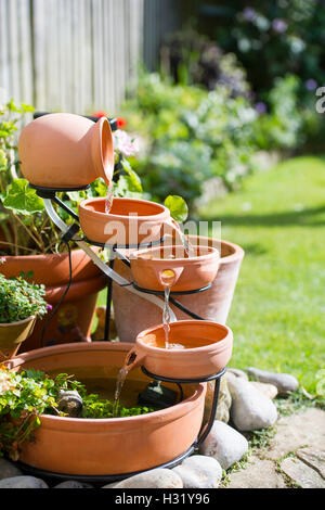 Una terracotta acqua utilizzando la funzione di energia solare in garden REGNO UNITO Foto Stock