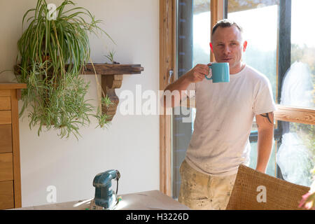 Legno falegname avente una pausa dal lavoro e godersi una tazza di tè al sole Foto Stock