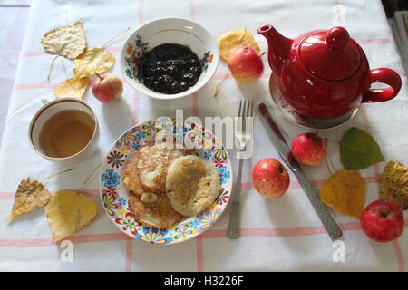 Stuzzicanti sana colazione vegetariana da golden frittelle con ripieno di mele, tè verde e inceppamento nella mattina di autunno Foto Stock