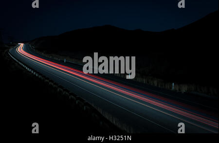 Sentieri di luce dalle automobili si muove velocemente nella tarda serata. Concetto di alta velocità Foto Stock