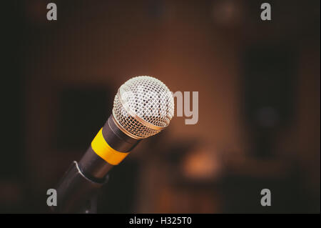 Microfono vicino fino in music studio, fuori fuoco tappa oscura in background Foto Stock