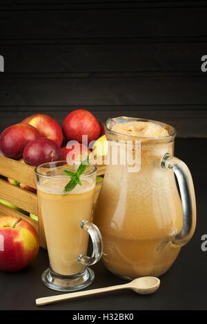 Premuto fresco succo di mela non filtrato. Il succo di mela e le mele su un tavolo di legno. Un succo sano per gli atleti. Autunno raccolto apple Foto Stock