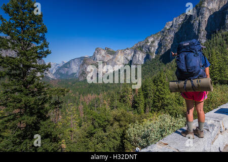 Zaino in spalla sul muro a vista di tunnel affacciato sulla valle di Yosemite nel Parco Nazionale di Yosemite in California, Stati Uniti d'America Foto Stock