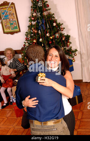 Donna che mantiene un regalo di Natale e abbracciando il credito uomo © Luigi Innamorati/Sintesi/Alamy Stock Photo.Caption locale *** . Foto Stock