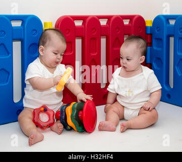 Due bambini giocare con anello di impilamento del giocattolo Foto Stock