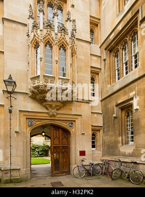 Ornati in entrata al palazzo storico in stile gotico finestra di baia, arcuato porta in legno & biciclette appoggiata sulla parete a Oxford Regno Unito Foto Stock