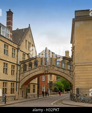 Ornato Ponte dei Sospiri di Oxford, con biciclette appoggiata contro la parete di edificio adiacente, pedoni passando da & blue sky, Inghilterra Foto Stock