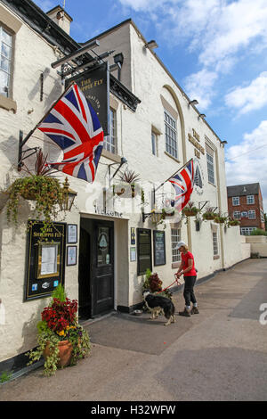 Una donna e il suo cane al di fuori del Shroppie Fly o il Shropshire Fly public house o pub Audlem Cheshire England Regno Unito Foto Stock