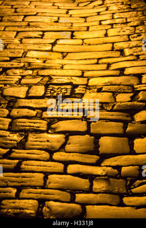 Ciottoli/ pietre per pavimentazione dato un bagliore dorato sotto presso l illuminazione notturna Foto Stock