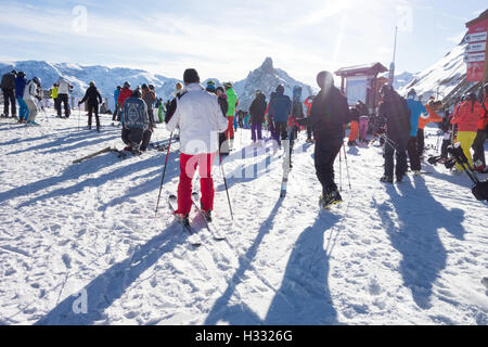 Courchevel 1850, Saulire Summit - sciatori lasciando ascensori e voce a più alto viene eseguito. Picco di Aiguille de la frutta è a distanza Foto Stock