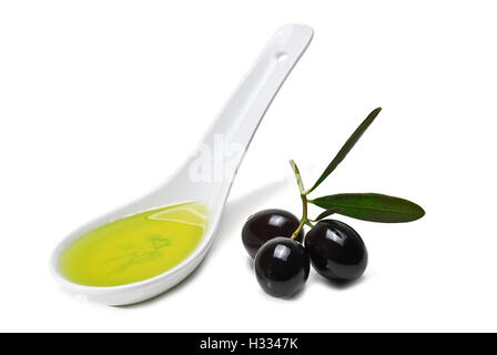 Olive nere e un cucchiaio di olio di oliva isolate su uno sfondo bianco. Foto Stock