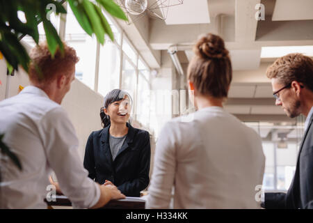 Diversi gruppi di persone di affari aventi riuniti insieme in un ufficio moderno. Imprenditrice spiegando nuove idee di business a collea Foto Stock
