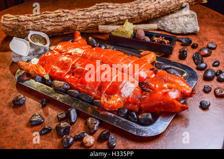 Maiale arrosto su un tavolo in legno, cucina Cinese Foto Stock