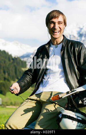 L'uomo, 29, su un classico scooter, Allgaeu, Bavaria Foto Stock