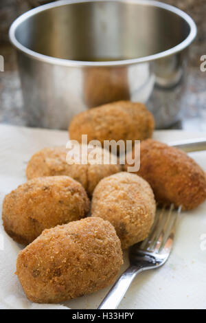 Palle di riso o supplì fritti in padella con olio di oliva Foto Stock