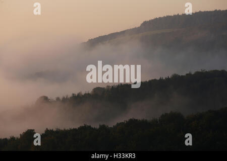 Il Rising Sun provoca un bagliore rosa attraverso la foschia sopra il South Downs National Park a Houghton vicino a Arundel in West Sussex, Regno Unito Fr Foto Stock