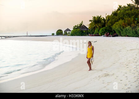 Donna sulla spiaggia al tramonto, Maldive Foto Stock