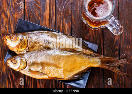Pesce affumicato su piastra e su un tavolo Foto Stock
