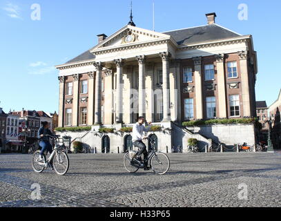 Gli studenti asiatici ciclo nella parte anteriore del Municipio (stadhuis) sul Grote Markt (piazza principale), Groningen, Paesi Bassi Foto Stock