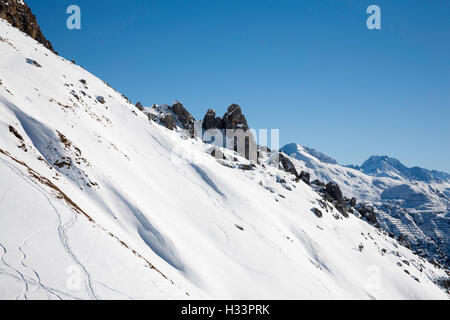 Le formazioni rocciose sporgenti al di sopra della neve sopra Lech am Arlberg Austria Foto Stock