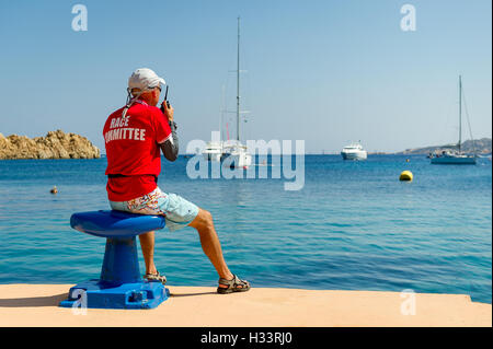 Gara di vela arbitro guardando al yacht nella splendida baia Foto Stock