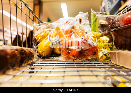 Supermercato shopping nel carrello spesa nel carrello spesa spingendo intorno store shop supermercati alimentari alimentari carote patate Foto Stock