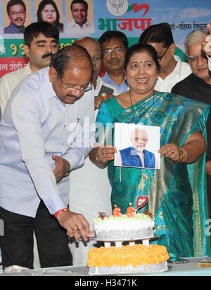 BJP lavoratori tagliare una fetta di torta in Mumbai, India il 17 settembre 2016, in occasione della celebrazione del Primo Ministro Narendra Modi il compleanno Foto Stock