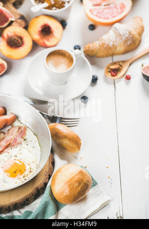 Uovo fritto con salsicce e bacon, pane, croissant, caffè Foto Stock