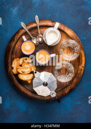 Il caffè espresso, i cantucci, biscotti e latte su legno scheda servente Foto Stock