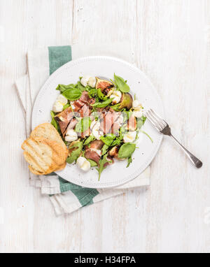 Il Prosciutto, rucola, basilico, fichi insalata e un bicchiere di vino rosso Foto Stock