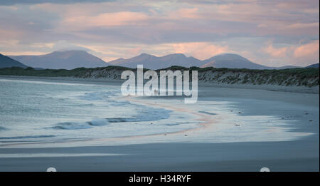 Coppia sulla spiaggia occidentale Berneray al crepuscolo, Ebridi Esterne, Western Isles, Scozia Foto Stock