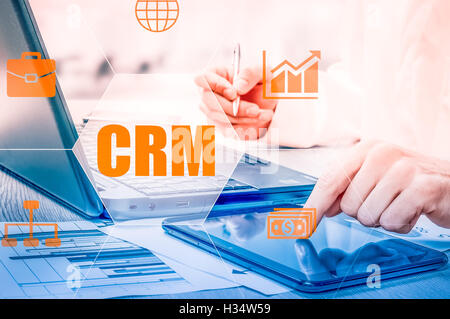 Business, tecnologia Internet e networking concetto. Imprenditore lavorando sul suo computer portatile in ufficio, selezionare l'icona CRM. Gestione delle relazioni con i clienti. Foto Stock