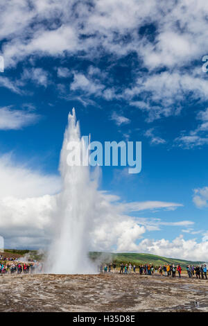 I turisti si riuniscono per guardare Strokker geyser (geysir), un eruzione a molla Haukadalur, Islanda, regioni polari Foto Stock