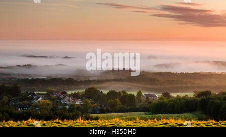 Guardando oltre il villaggio di Delamere da Eddisbury Hill ad una coltre di nebbia e la nebbia giacente su la pianura del Cheshire, Cheshire, Regno Unito Foto Stock