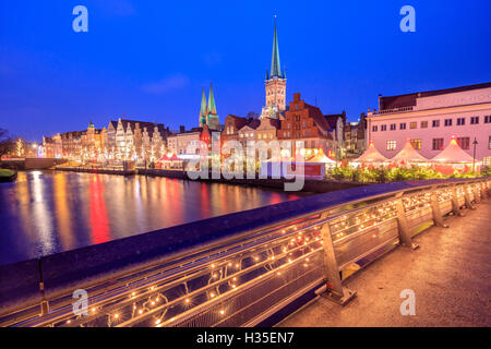 Vista notturna di tipiche case e la cattedrale si riflette nel fiume Trave, Lubecca, Schleswig Holstein, Germania Foto Stock