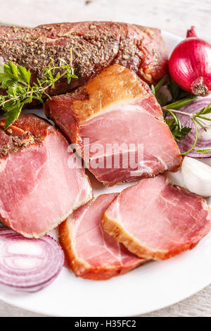 Affumicato tagliato lombo di maiale carne sulla piastra bianca Foto Stock