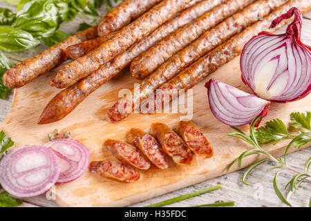 Salame di sottili fette di salumi tagliere di legno Foto Stock