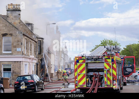 Scottish fuoco e il servizio di soccorso dei Vigili del fuoco combattono una sfolgorante shop con tubi flessibili. Elie e Earlsferry Fife Scozia UK Gran Bretagna Foto Stock