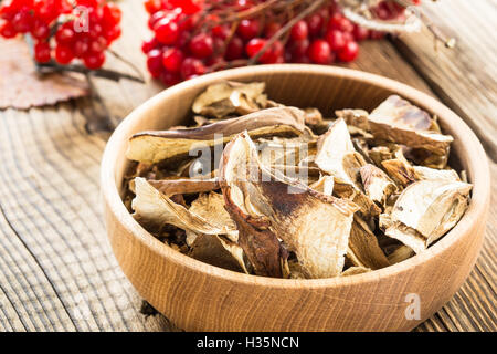 Funghi porcini secchi nella ciotola di legno su una tavola in legno rustico Foto Stock