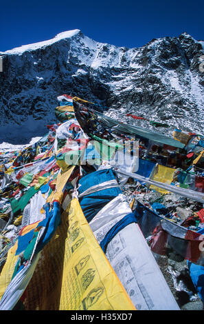 Bandiere di preghiera sulla pietra Dolma a Dolma La pass, a 5,636 metri (18.600 piedi) è il punto più alto del Kailas Foto Stock