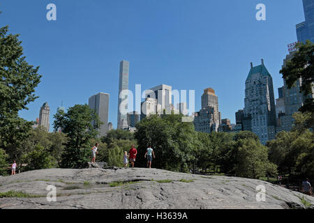 Bambini che giocano su arbitro Rock, Central Park. Vista sud verso il Midtown Manhattan, New York, New York, Stati Uniti. Foto Stock